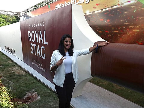 A woman poses with what is claimed to be the world's largest cricket bat after unveiling it in support of the Indian T20 team on the eve of the ICC Men's T20 World Cup in Hyderabad, India.