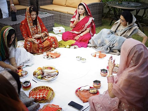 Indian expat women performing offering their evening prayer on Karwa Chauth at a Dubai home on Sunday.