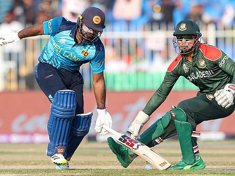 Sri Lanka's Kusal Perera (left) runs to make his ground as Bangladesh's Nurul Hasan reaches for the ball during the Cricket Twenty20 World Cup match in Sharjah, UAE.