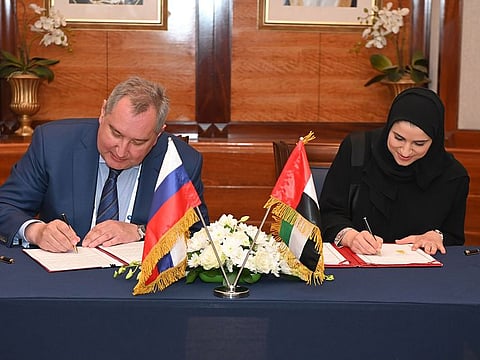 UAE's Sarah Bint Yousef Al Amiri (R) signing the agreement with Russia's Dmitry Rogozin