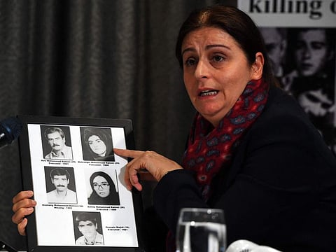 Plaintiff Farzaneh Majidi holds pictures of her executed family members as she attends a press conference organised by The UK Representative Office of the National Council of Resistance of Iran (NCRI) in Glasgow on October 13, 2021 after they filed legal complaints against Iranian President Ebrahim Raisi. The National Council of Resistance of Iran (NCRI) filed legal complaints against the Iranian President Ebrahim Raisi alleging crimes against humanity and genocide in reference to the killing of thousands of NCRI members in 1988.