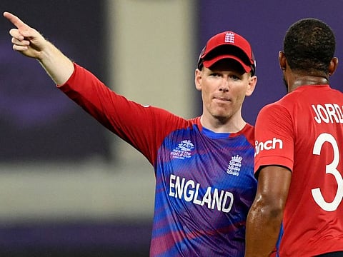 England's captain Eoin Morgan gestures next to his teammate Chris Jordan during the ICC Men’s Twenty20 World Cup cricket match against Australia at the Dubai International Cricket Stadium on October 30, 2021.
