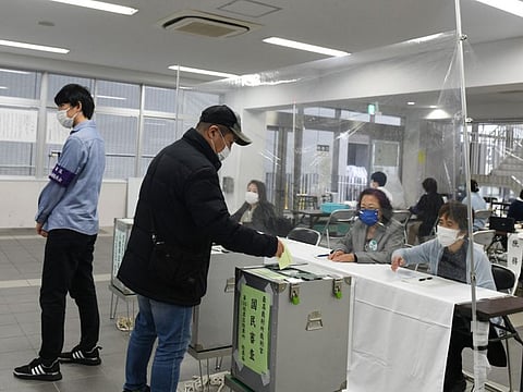 A voter casts a ballot at a polling location in the Shinjuku District of Tokyo, Japan, on Sunday, Oct. 31, 2021.