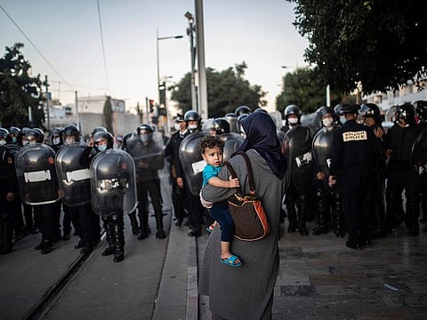 Security forces stand guard as they prepare to disperse a protest against the government enforcing of a mandatory COVID-19 vaccine pass, in Rabat, Morocco, Sunday, Oct. 31, 2021.