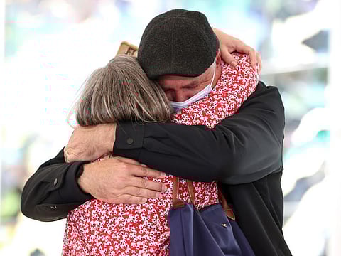 People embrace in the arrival hall at the international terminal of Sydney Airport on November 1, 2021. Vaccinated overseas travelers entering Australia's biggest states, New South Wales and Victoria, no longer need to quarantine on arrival, while millions of Australians living on the country’s east coast can finally leave their home soil without a permit.