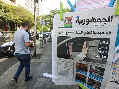 A man walks near a newspaper with a headline that reads 'Saudi Arabia announces a boycott with Lebanon' in Beirut on October 30, 2021.