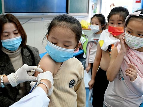 A child receives a vaccine at a school in Handan, in China's northern Hebi province on October 27, 2021, after the city began vaccinating children between the ages of 3 to 11.