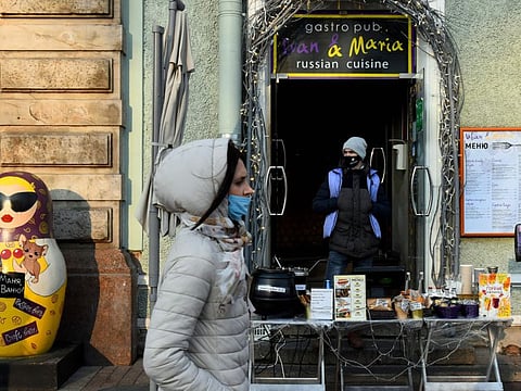 A woman walks by a cafe working take-out only on Nevsky Prospekt, in Saint Petersburg, on November 2, 2021.