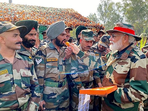 Indian Prime Minister Narendra Modi offers sweets to army soldiers on the occasion of Diwali, at Nowshera, in Rajouri on Thursday, November 4, 2021.