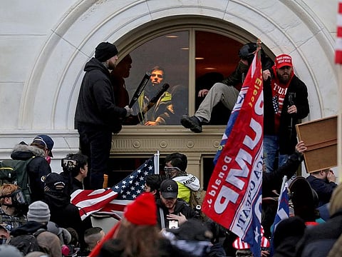 File: A mob of supporters of then-U.S. President Donald Trump climb through a window they broke as they storm the U.S. Capitol Building in Washington, U.S., January 6, 2021.