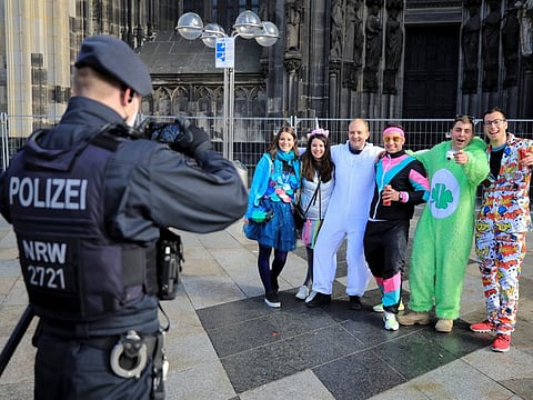 A police officer takes a picture of revellers during the so-called "fifth", or foolish carnival season, amid the spread of the coronavirus disease in Cologne, Germany, November 11, 2021.