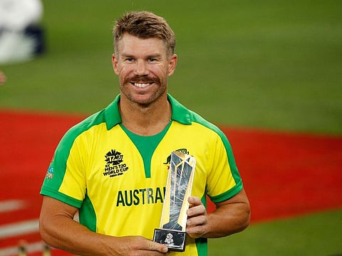 Australia's David Warner poses with the Player of the Tournament trophy after the ICC Men's T20 World Cup final against New Zealand at the Dubai International Stadium on November 14, 2021.