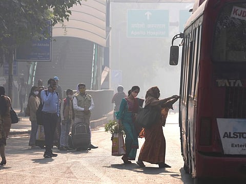 Commuters board a local transport amidst morning haze and toxic smog in New Delhi, India, on November 17, 2021.