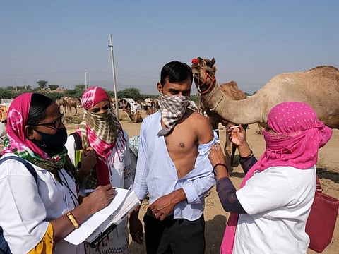 A health worker administers a dose of vaccine at the fairgrounds of the Pushkar Camel Fair in Pushkar, Rajasthan, on November 9, 2021.