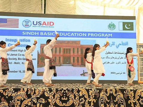 School students perform a tableau at the inauguration of the 77th USAID-built school in Sindh in Bin Qasim Town area of Karachi.
