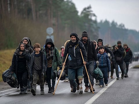 Migrants walking from the Polish border to a warehouse shelter on Thursday, Nov. 18, 2021, in Bruzgi, Belarus.