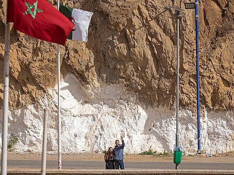 A picture taken from the Moroccan region of Oujda shows Algerians waving along the border with Morocco on November 4, 2021.