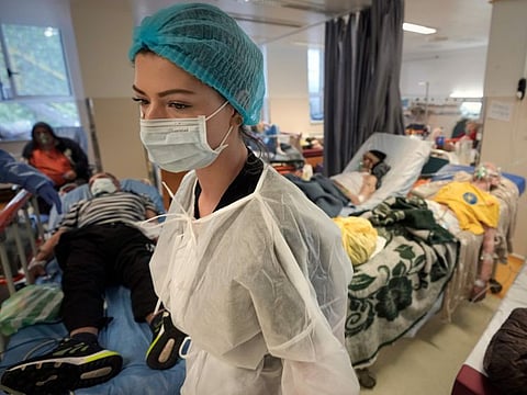 A member of the medical staff walks in a crowded COVID-19 isolation room at the University Emergency Hospital in Bucharest, Romania. “Cumulative reported deaths are projected to reach over 2.2 million by spring next year,” WHO said, up from the current 1.5 million.