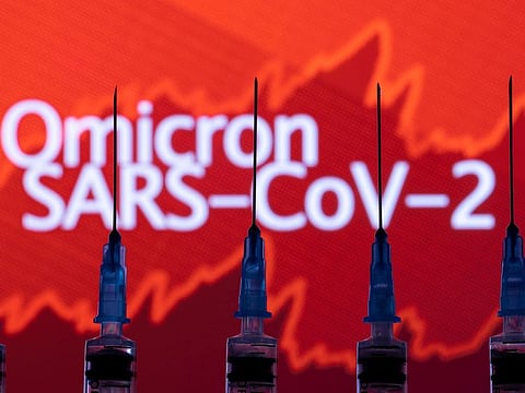 Syringes are seen in front of a displayed stock graph in the illustration taken on November 27, 2021. Following reports of the discovery of the new coronavirus variant, Omicron, stock markets crashed and several countries imposed a ban on flights from southern Africa.