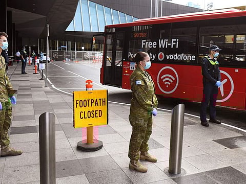 A file photo taken on December 7, 2020 shows members of the army and police greeting travellers arriving for hotel quarantine in Melbourne. Health officials in Australia said on November 28, 2021 they had detected the Covid Omicron strain for the first time after testing two passengers in hotel quarantine from southern Africa who flew into Sydney.