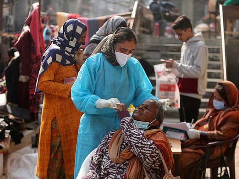 A health worker takes a nasal swab sample to test for COVID-19 in Jammu, India, Saturday, Nov. 27, 2021.