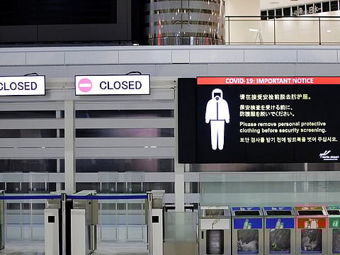 A notice about COVID-19 safety measures is pictured next to closed doors at a departure hall of Narita international airport on the first day of closed borders to prevent the spread of Omicron variant in Narita, east of Tokyo, on November 30, 2021.