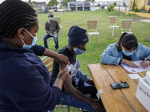A health worker administers a dose of the Pfizer-BioNTech Covid-19 vaccine at CAFDA (Cape Flats Development Association) in the Egoli township of Cape Town, South Africa, on Tuesday, Nov. 30, 2021. South African scientists were last week the first to identify the new variant now known as omicron, and while symptoms have been described as mild, the exact risk from the new strain is still uncertain. Photographer: Dwayne Senior/Bloomberg