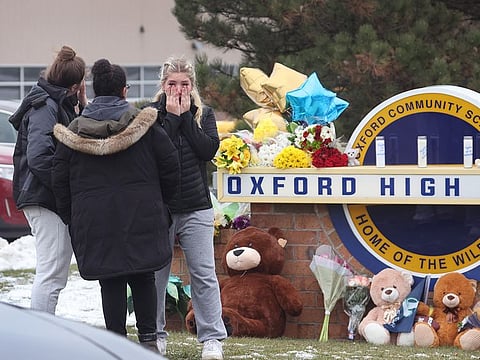 Mourners react as they visit a makeshift memorial outside of Oxford High School on December 01, 2021 in Oxford, Michigan.