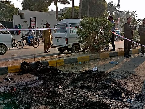 Police officers stand guard at the site of incident, where a Sri Lankan citizen lynched by mob, at outside a factory in Sialkot, Pakistan, Friday, Dec. 3, 2021. A Muslim mob attacked a sports equipment factory in Pakistan's eastern Punjab province on Friday, killing a Sri Lankan over allegations of blasphemy, police said.