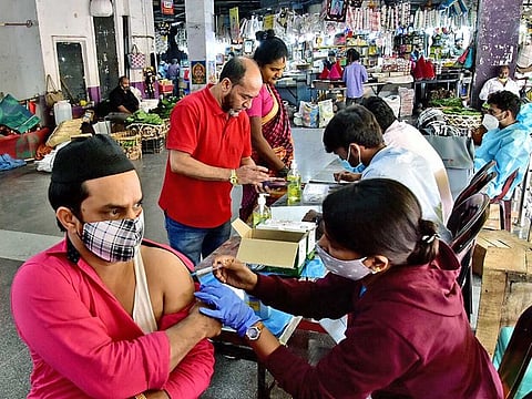 A healthcare worker inoculates a beneficiary with a dose of the COVID-19 vaccine during a vaccination drive amid a threat of a new COVID variant 'Omicron', at City Market, in Bengaluru on Saturday, December 4, 2021.
