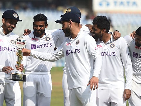 India's Virat Kohli (centre) holds the trophy after winning the fourth day of the second Test cricket match between India and New Zealand at the Wankhede Stadium in Mumbai.