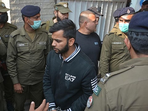 Policemen escort a suspect accused for the killing of Sri Lankan's factory manager as they leave an anti-terrorist court in Gujranwala on December 6, 2021.