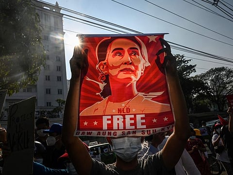 In this file photo taken on February 15, 2021, a protester holds up a poster featuring Aung San Suu Kyi during a demonstration against the military coup in front of the Central Bank of Myanmar in Yangon. Myanmar's junta on December 6, 2021 jailed ousted leader Aung San Suu Kyi for four years for incitement and breaching COVID-19 rules, a spokesman said, the first of several possible convictions that could jail the Nobel laureate for decades.