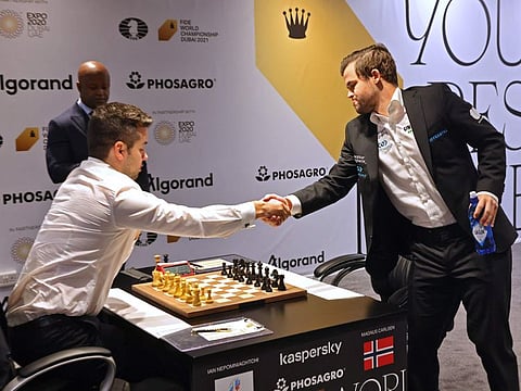 Norway's reigning world champion Magnus Carlsen (right) and challenger Ian Nepomniachtchi exchange pleasantries during their World Championship game in Dubai on Tuesday.