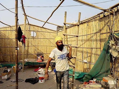 A farmer dismantles a temporary structure from a highway at the Delhi-Haryana state in Singhu on December 9, 2021, formally ending year-long mass protests.