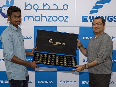 Akshay Eriyakadan Aravindan receives his prize of 1kg gold from Farid Samji, CEO of Ewings, the managing operator of Mahzooz.