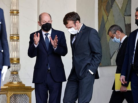 German Chancellor Olaf Scholz speaks with President Emmanuel Macron after their meeting at the Elysee Palace, in Paris on December 10, 2021.
