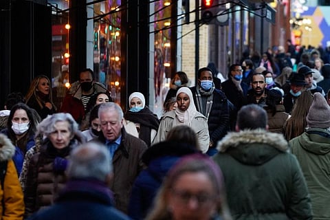 Shoppers walk along Oxford Street in central London on December 10, 2021. The UK government will from Monday tighten virus restrictions in England as Omicron variant cases surge, including guidance to work from home and mandatory COVID passports.