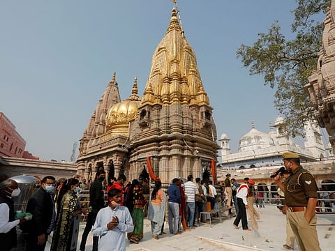 A policeman uses a mike to urge devotees to maintain distance inside the Kashi Vishwanath Temple compound ahead of the inauguration of the new Kashi Vishwanath Temple corridor by India's Prime Minister Narendra Modi in the northern city of Varanasi, India, December 12, 2021.