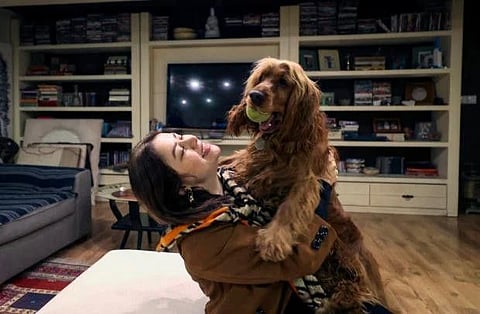 An Iranian woman plays with her dog at home in northern Tehran, on December 5, 2021. A proposed law to ban pets submitted by conservative Iranian lawmakers, pits growing numbers of people with pets against those who consider the practice decadent and hold that under Islamic law dogs, like pigs, are unclean.