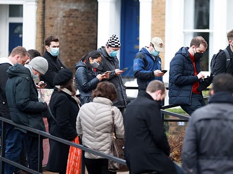 People queue outside a COVID-19 vaccination centre at a church in London, on December 13, 2021.