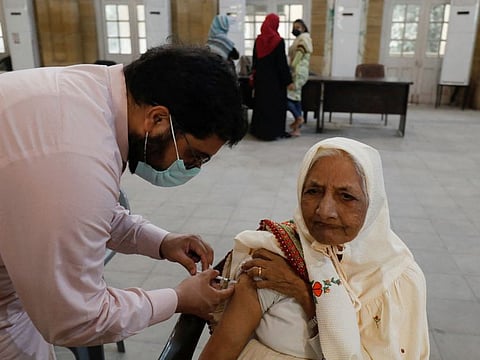 A woman receives a dose of COVID-19 booster vaccine in Karachi, on December 13, 2021. Among the cities whose eligible populations are largely vaccinated against COVID-19, Islamabad stands first as according to the official data more than 90 per cent of its eligible citizens have been partially and 75 per cent fully vaccinated against COVID-19.