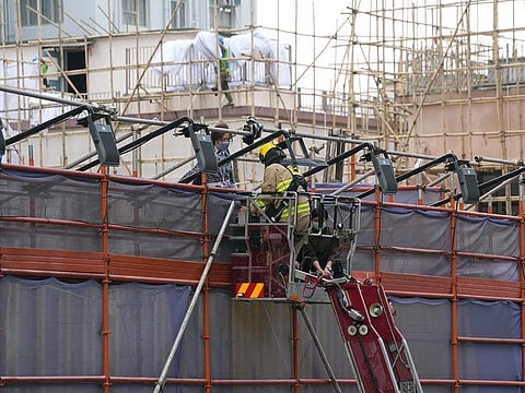 A firefighter rescues people trapped in a fire that broke out at the World Trade Centre in Hong Kong on December 15, 2021.