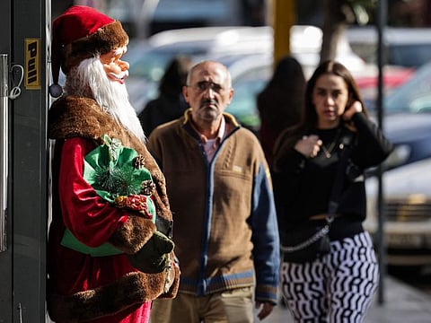 This picture taken on December 14, 2021 shows a view of a statue of Saint Nicholas (Father Christmas or Santa Claus) outside the entrance of a toy shop in the popular market of the Burj Hammoud neighbourhood of Beirut.