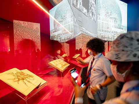Students study the pages of famous date archives on display at the France Pavilion