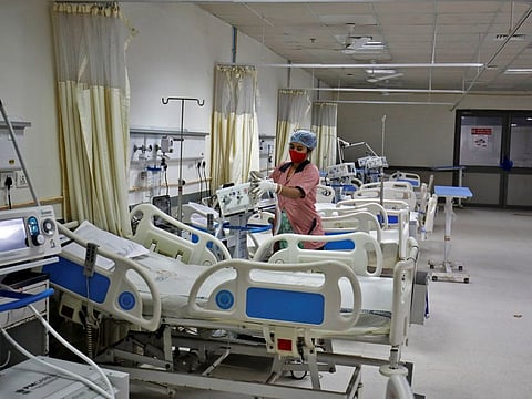 A staff member cleans medical equipment inside a ward that is set up to treat people infected with Omicron variant at the Civil Hospital in Ahmedabad.