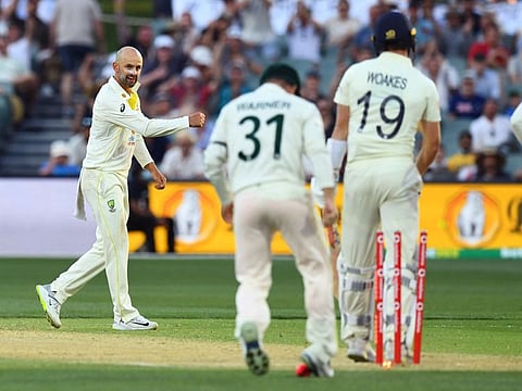 Australia's Nathan Lyon (left) celebrates after clean bowling England's Chris Woakes on the third day of the second Ashes Test on Saturday.