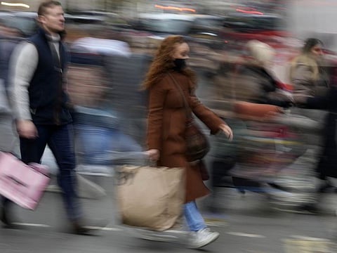 Shoppers rush along Oxford Street, Europe's busiest shopping street, in London on December 18, 2021. Soaring infections in Britain driven in part by the omicron variant of the coronavirus are rattling Europe.