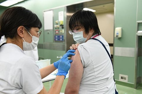 A nurse receives a booster shot of the Pfizer-BioNTech vaccine at Chiba University Hospital in Chiba, Japan.