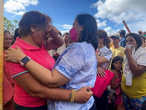 Philippine Vice-President Leni Robredo, right, comforts a woman after inspecting damages due to Typhoon Rai at Dinagat islands, southern Philippines on Sunday December 19, 2021.